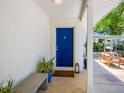 Charming front entry with a blue door, stylish tile flooring, and cozy bench seating at 3629 Almeria Ave, Sarasota, FL 34239