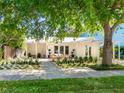 Inviting exterior featuring a covered porch, white facade, and beautifully landscaped front yard at 3629 Almeria Ave, Sarasota, FL 34239