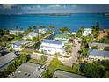 Beautiful aerial view of waterfront homes, palm trees, and a canal on a sunny day with a blue sky at 401 20Th Pl, Bradenton Beach, FL 34217