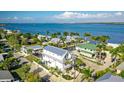 Stunning aerial view of a white two-story home near the water with a balcony surrounded by tropical landscaping at 401 20Th Pl, Bradenton Beach, FL 34217