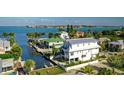 Beautiful white home with a balcony overlooking the water, complete with lush landscaping, and neighboring waterfront properties at 401 20Th Pl, Bradenton Beach, FL 34217