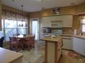 Bright eat-in kitchen with white cabinets, center island, and sunlit breakfast nook with a large window at 4555 Bay Club Dr # 22, Bradenton, FL 34210