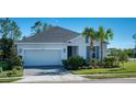 Charming single-story home with a two-car garage, palm trees and manicured lawn at 4706 Roycroft Ter, Parrish, FL 34219