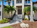 Inviting front entrance featuring a modern door, complemented by lush landscaping and a stone pathway at 4940 Peaceable Way, Sarasota, FL 34242