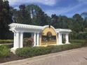Entrance to the Las Palmas Luxury Condominiums community with lush greenery at 5701 Bentgrass Dr # 18-203, Sarasota, FL 34235