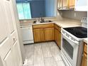 Cozy kitchen with stainless steel sink, white appliances, and tile flooring at 5701 Bentgrass Dr # 18-203, Sarasota, FL 34235