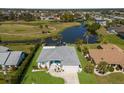 Aerial view of a home featuring a screened in pool, overlooking a tranquil pond and golf course at 6 Bunker Cir, Rotonda West, FL 33947