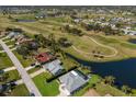An aerial view showcasing the property's location near a golf course, pond, and lush greenery at 6 Bunker Cir, Rotonda West, FL 33947
