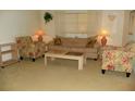 Comfortable living room with floral armchairs, a neutral sofa, and soft natural light at 6042 Red Maple Rd # 1001, Bradenton, FL 34210