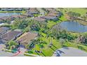 Aerial view of a home in a golf community, featuring mature trees, a pond and manicured landscaping at 6857 Wild Lake Ter, Bradenton, FL 34212