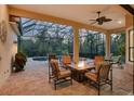 Relaxing covered patio with brick flooring, comfortable seating, a fire pit, and a view of the backyard pool at 7665 Portstewart Dr, Lakewood Ranch, FL 34202