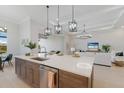 Modern kitchen with a large island, quartz countertops, stainless steel appliances, and seamless access to the living area at 8364 Sea Glass Ct, Sarasota, FL 34240