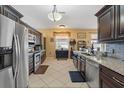 Well-lit kitchen featuring stainless steel appliances, tile flooring, granite countertops and dark wooden cabinets at 9408 69Th E Ave, Palmetto, FL 34221