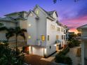 Elegant three-story home featuring a clean white exterior, a two-car garage and a charming entrance at 116 Garden Ln, Sarasota, FL 34242