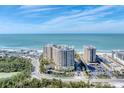 Aerial shot showcasing buildings near a beach, a coastal road, and water views at 1300 Benjamin Franklin Dr # 304, Sarasota, FL 34236
