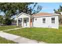 Inviting single-story home featuring a bright orange front door, covered entry way and a well-maintained lawn at 1301 12Th S St, St Petersburg, FL 33705