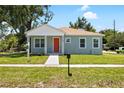 Well-manicured lawn complements this beautifully renovated single-story home with a bright orange front door at 1301 12Th S St, St Petersburg, FL 33705