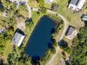 Aerial view of a rural property featuring a pond surrounded by trees and several outbuildings at 1471 Arcadia Ave, Sarasota, FL 34232