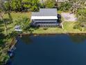 Aerial view of a beautiful white house with a porch by a lake at 1471 Arcadia Ave, Sarasota, FL 34232