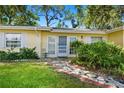 Inviting front entrance with a decorative walkway, tiled landing, and charming details at 1870 Jasmine Dr, Sarasota, FL 34239