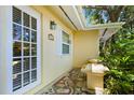 Covered front porch featuring a tiled floor, exterior bench, and bright stucco exterior at 1870 Jasmine Dr, Sarasota, FL 34239