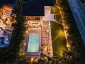 Aerial view of backyard with pool, patio, and stylish outdoor dining area lit with string lights at 2305 Pine Ter, Sarasota, FL 34231
