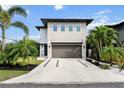 Beautiful two-story home featuring a modern exterior, a spacious driveway, and lush landscaping at 2305 Pine Ter, Sarasota, FL 34231