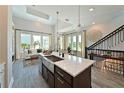 Gourmet kitchen featuring an expansive island with a stainless steel sink, and a view of the living area at 2401 Ezzell Ct, Sarasota, FL 34237