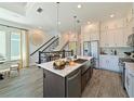 Bright, open kitchen with stainless appliances, large island, granite countertops and wood-look tile floors at 2401 Ezzell Ct, Sarasota, FL 34237