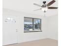 Bright living room with a ceiling fan, neutral color palette, a new front door, and lots of natural light at 2916 Cambridge Dr, Sarasota, FL 34232