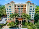 Stately multi-story building with manicured landscaping and a charming portico entrance framed by mature palm trees at 3603 N Point Rd # 702, Osprey, FL 34229