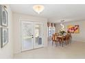 Bright dining area with white tile floors, modern light fixture, and a view to the outside patio at 3876 Torrey Pines Blvd, Sarasota, FL 34238