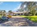 Charming single-story home features mature landscaping, a tile roof, and a long driveway at 3876 Torrey Pines Blvd, Sarasota, FL 34238