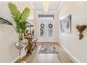 Elegant home entryway featuring a decorative chandelier, wood floors, and ornate accents at 4856 Coastal Days Ln, Bradenton, FL 34211