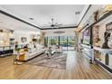 Spacious living room with a modern fireplace, large TV, and sliding glass doors to the pool at 4856 Coastal Days Ln, Bradenton, FL 34211