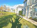 Charming blue two-story townhome with a well-manicured lawn and walkway along the pond at 5560 Rosehill Rd # 105, Sarasota, FL 34233