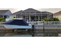 Photo of a pale blue covered boat docked behind a waterfront home with a screened-in porch overlooking the water at 581 Mast Dr, Bradenton, FL 34208