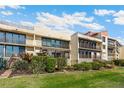 Condominium exterior view with multi-story facade, balconies, and lush landscaping, perfect for relaxing outdoor living at 6430 Sun Eagle Ln # 103, Bradenton, FL 34210