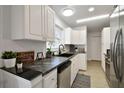 Bright kitchen features white cabinets, granite counters, stainless steel appliances, and a black sink at 701 37Th Avenue E Dr, Bradenton, FL 34208