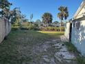 Spacious backyard featuring a combination of grass, gravel, and greenery at 704 Chippy Ln, Nokomis, FL 34275