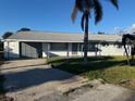Inviting single-story home featuring an attached garage, long driveway, and mature landscaping for a comfortable living at 704 Chippy Ln, Nokomis, FL 34275