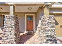 Inviting front entryway with a wood door and beautiful stone columns, welcoming you to this lovely home at 7214 35Th E Ln, Sarasota, FL 34243