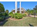 Well-manicured front yard with lush landscaping and mature trees offering shade and privacy to the home at 7214 35Th E Ln, Sarasota, FL 34243