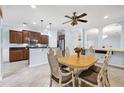 Open dining room with stylish chandelier and views into the modern kitchen at 7887 Limestone Ln # 12-102, Sarasota, FL 34233