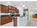 Well-lit kitchen with granite countertops, stainless steel appliances, and dark wood cabinets at 7887 Limestone Ln # 12-102, Sarasota, FL 34233