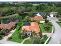 Beautiful home featuring well-manicured lawn and garden, mature palms and barrel tile roof in lakefront community at 7934 Royal Birkdale Cir, Lakewood Ranch, FL 34202