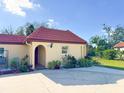 Quaint home with a red tile roof and meticulously kept landscaping under a bright blue sky at 916 W Faith Cir, Bradenton, FL 34212