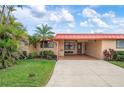 Inviting single-story home featuring lush landscaping, a covered entryway, and a spacious driveway at 9527 Azure Cv, Bradenton, FL 34210
