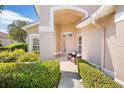 Inviting front porch with tiled flooring and seating area, framed by manicured hedges at 9539 Forest Hills Cir, Sarasota, FL 34238