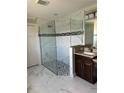 Bathroom featuring a glass-enclosed shower with modern tiles and granite countertop at 1056 Tampa Rd, Venice, FL 34293